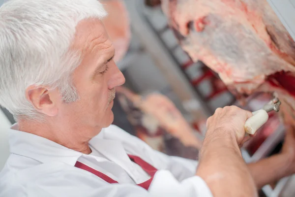 Carniceiro cortando pedaço de carne — Fotografia de Stock