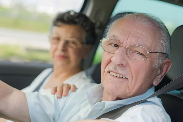 Pareja mayor mirando por la ventana del coche — Foto de Stock