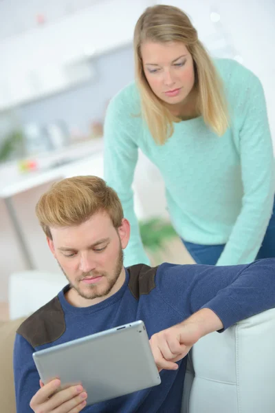 Couple using their tablet on the sofa — Stock Photo, Image