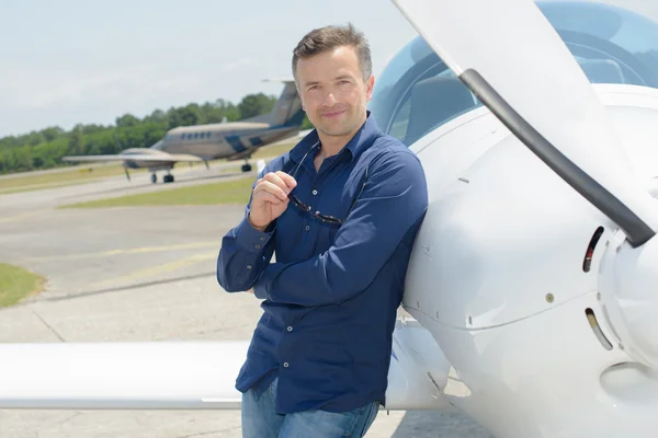 Porträt eines Mannes, der sich an Flugzeuge lehnt — Stockfoto