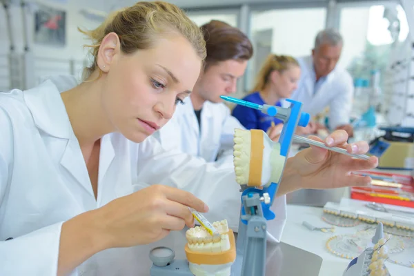 Жінка-лаборант, що працює над зубними протезами — стокове фото