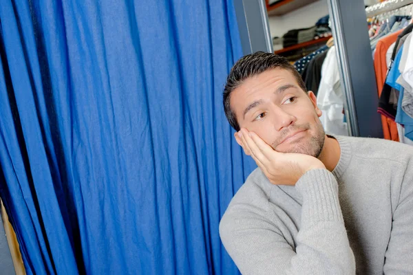 Homme attendant patiemment devant la salle d'essayage — Photo