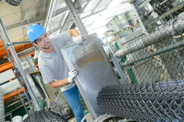 Trabalhador da fábrica com rolos de arame — Fotografia de Stock