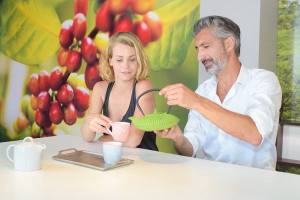 Mann schenkt Heißgetränk für Begleiter ein — Stockfoto