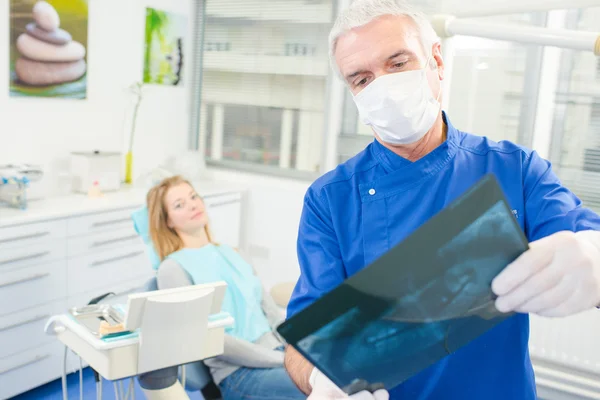 Dentista examinando una imagen de rayos X — Foto de Stock