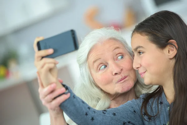 Dívka s fotografii sebe a babička — Stock fotografie