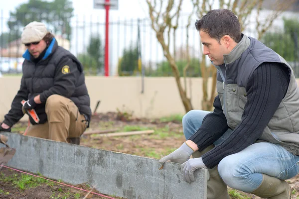 Bouwers aan het werk in een tuin — Stockfoto