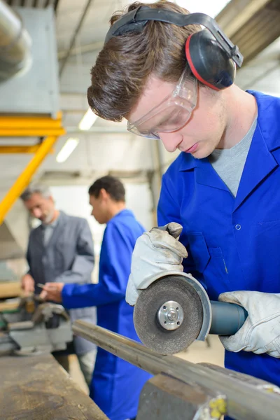 Jovem aprendiz usando um cortador de metal — Fotografia de Stock