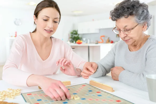 Äldre kvinna spela ett brädspel — Stockfoto