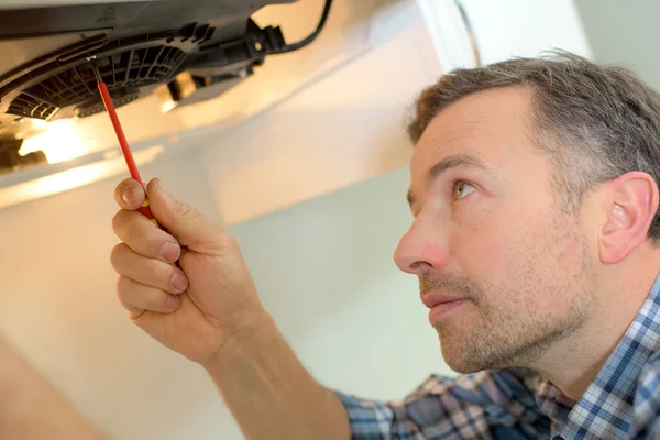 Fixing a kitchen extraction unit — Stock Photo, Image