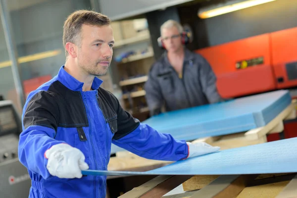 Workman blad van materialen op de pallet te plaatsen — Stockfoto