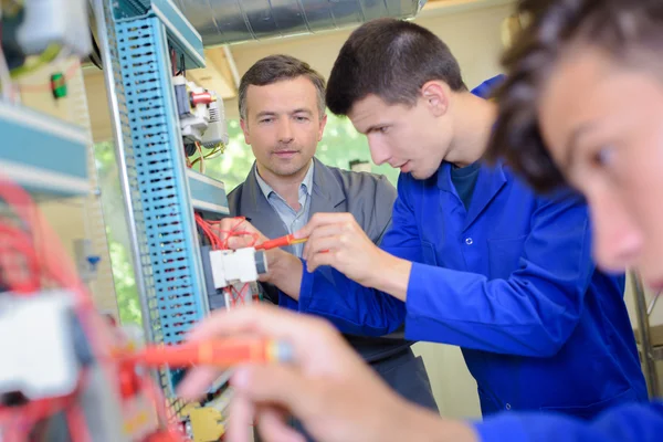 Tanár megfigyelése diákok dolgozó elektromos áramkörök — Stock Fotó