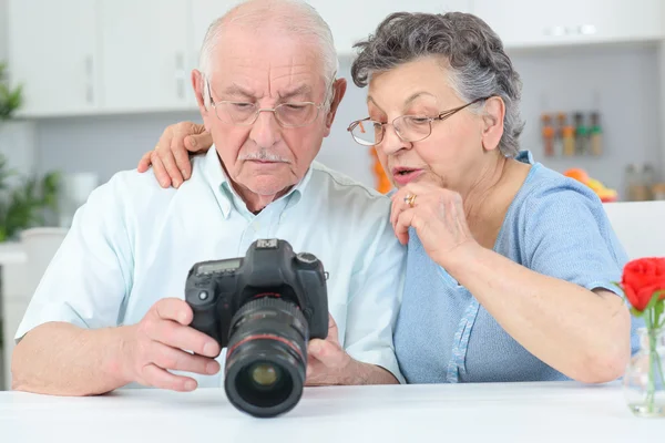 Starší pár, prohlížení fotografií na displeji na digitální fotoaparát — Stock fotografie