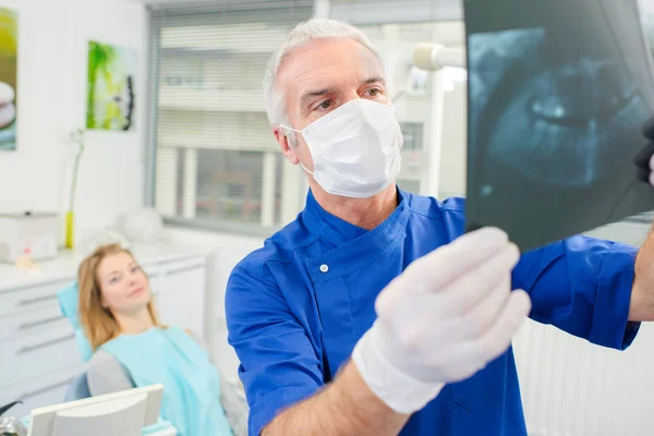 Dentist holding up an x-ray — Stock Photo, Image