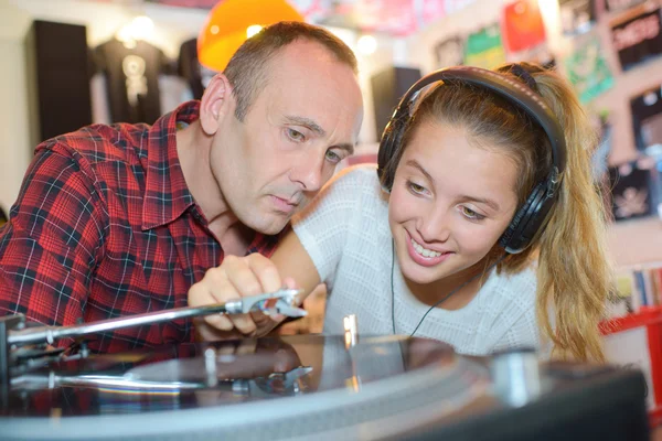 Mann beobachtet Dame beim Spielen von Schallplatte — Stockfoto