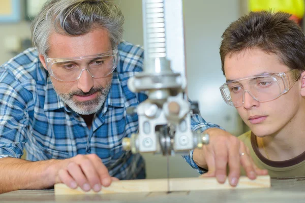 Lehrling beobachtet Tutor mit Säge — Stockfoto