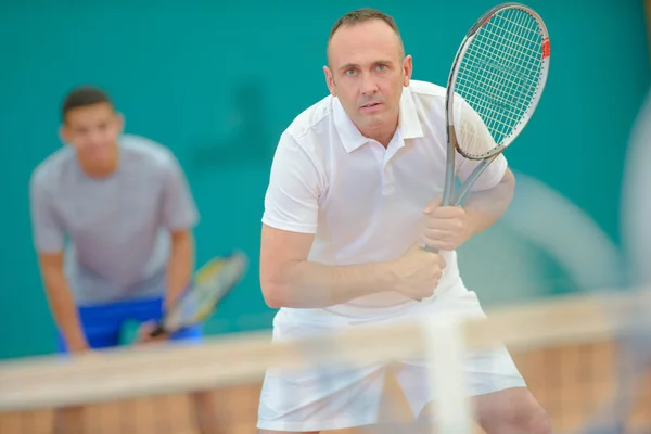 Män spelar dubbel tennis — Stockfoto