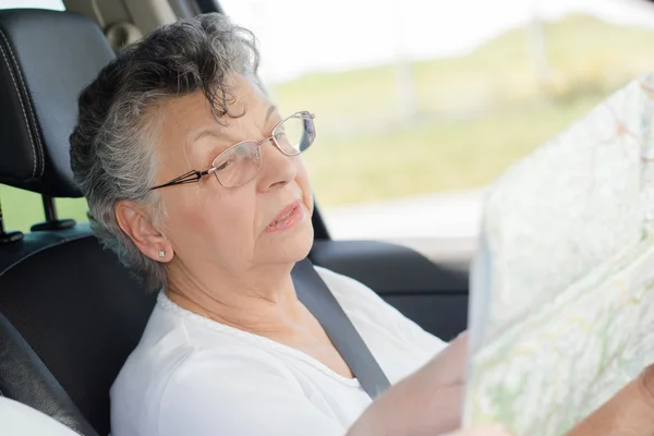 Oudere vrouw met een kaart — Stockfoto