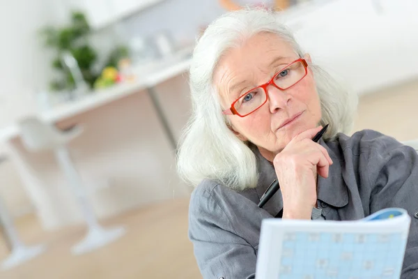 Oude laatste doet een kruiswoordraadsel — Stockfoto