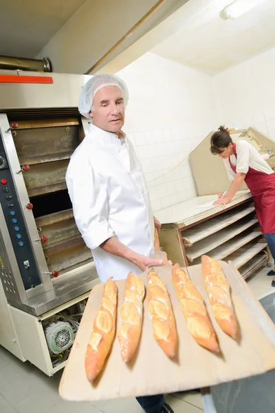 Fresh bread coming out of the oven — Stock Photo, Image
