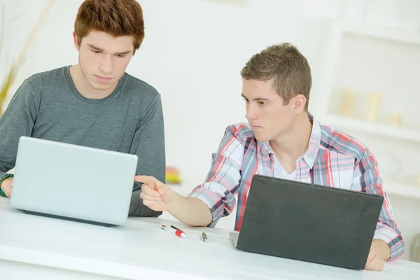 Dos estudiantes masculinos usando computadoras portátiles —  Fotos de Stock