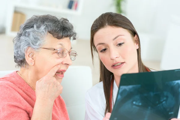 Doutor mostrando raio-X para senhora sênior — Fotografia de Stock