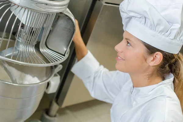 Baker using industrial machine to mix dough — Stock Photo, Image