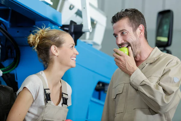 男性同僚が緑のリンゴを噛んだら笑う女性は — ストック写真