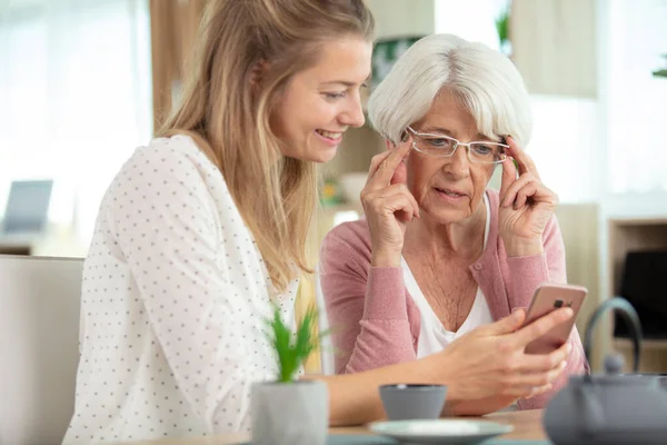 Moeder Haar Dochter Kijken Naar Foto Een Telefoon Scherm — Stockfoto