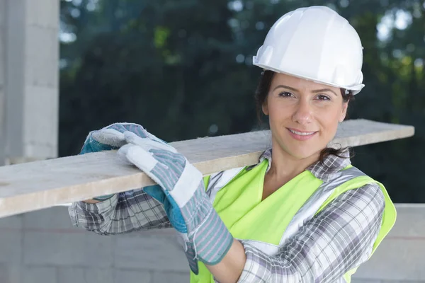 Byggmästare Och Kvinnlig Lärling Som Bär Trä Plats — Stockfoto