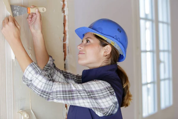 Vrouw Verwijdert Behang Met Een Spatel — Stockfoto