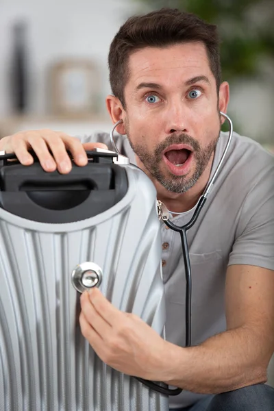 Geschokte Man Houdt Stethoscoop Aan Zijn Koffer — Stockfoto