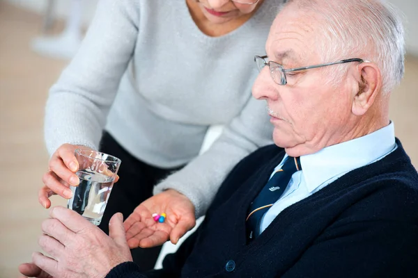 Заботливая Старшая Жена Дает Таблетки Своему Больному Мужу — стоковое фото