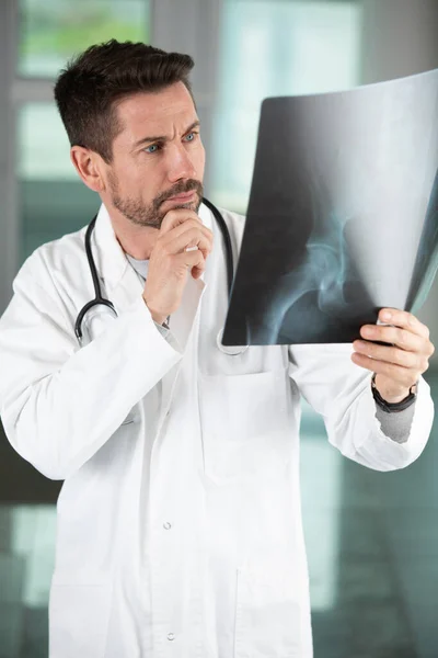 Besorgter Arzt Schaut Sich Röntgenbild — Stockfoto