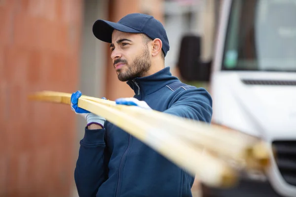 Younger Carpenter Holds Wooden Planks — Stock Photo, Image