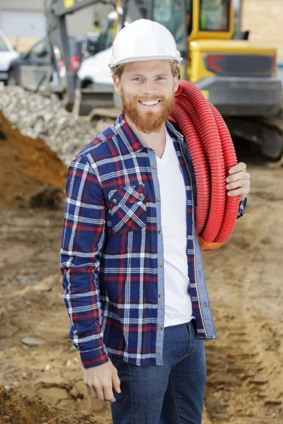 Man Byggare Bär Rött Rör Axeln — Stockfoto