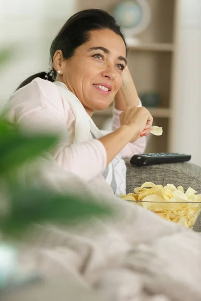 Eine Frau Isst Chips Während Sie Fernsieht — Stockfoto