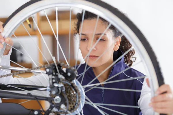 自転車の車輪で働く女性は — ストック写真