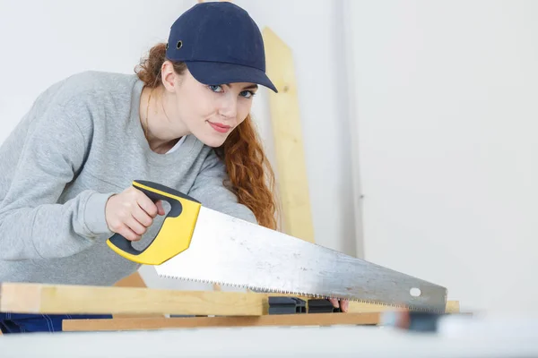 Young Craftswoman Cutting Wooden Board Handsaw Indoors — Stock Photo, Image