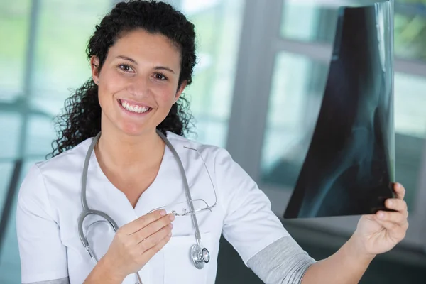 Leende Kvinnlig Läkare Tittar Röntgen — Stockfoto