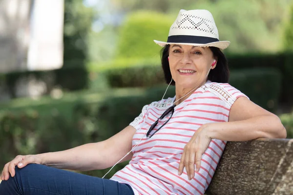 Femme Âgée Assis Sur Banc Portant Des Écouteurs — Photo