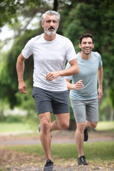 公園をジョギングする2人の男 — ストック写真