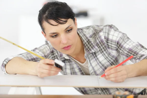 Jong Volwassen Vrouw Meten Van Een Houten Plank — Stockfoto