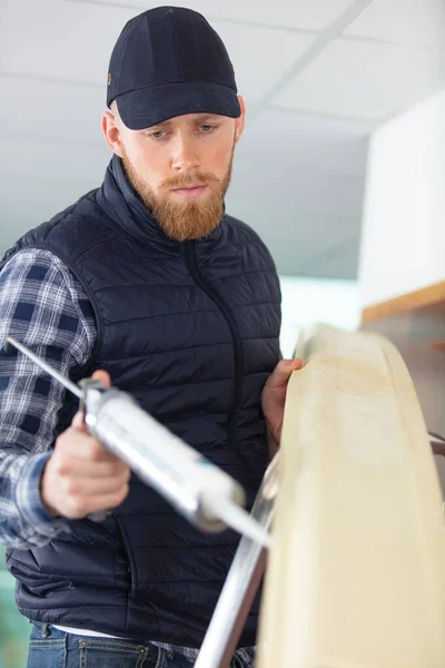 Caucasian Man Finishes Crown Moulding Installation Caulk Sealant — Stock Photo, Image