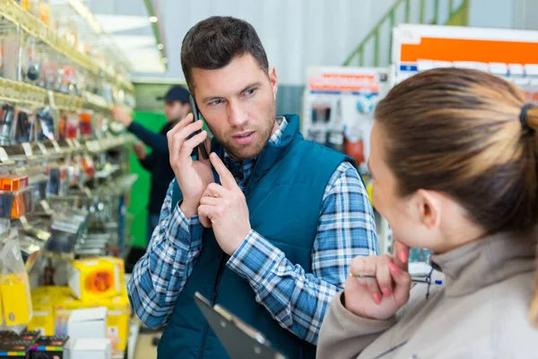 Man Använder Telefon Järnaffär — Stockfoto