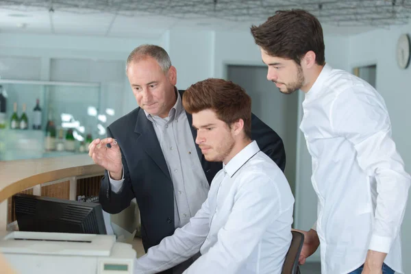 Young Men Training Hotel Reception Desk — Stock Photo, Image