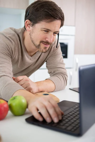 Young Man Using Headset Phone Laptop Kitchen — Stock Photo, Image