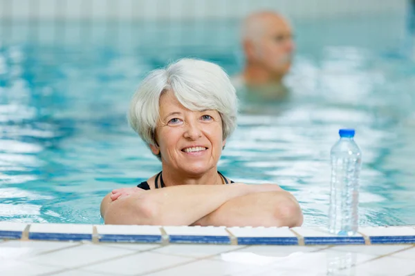 Yüzme Havuzundaki Yaşlı Kadın Yanında Şişe Suyla — Stok fotoğraf