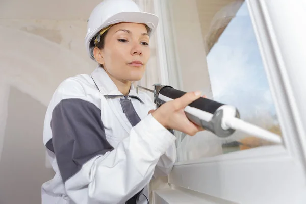 在房屋内安装窗户的女建筑工人 — 图库照片