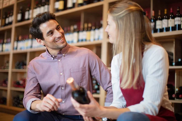 女性の売り手はワイン店で助言を与えます — ストック写真
